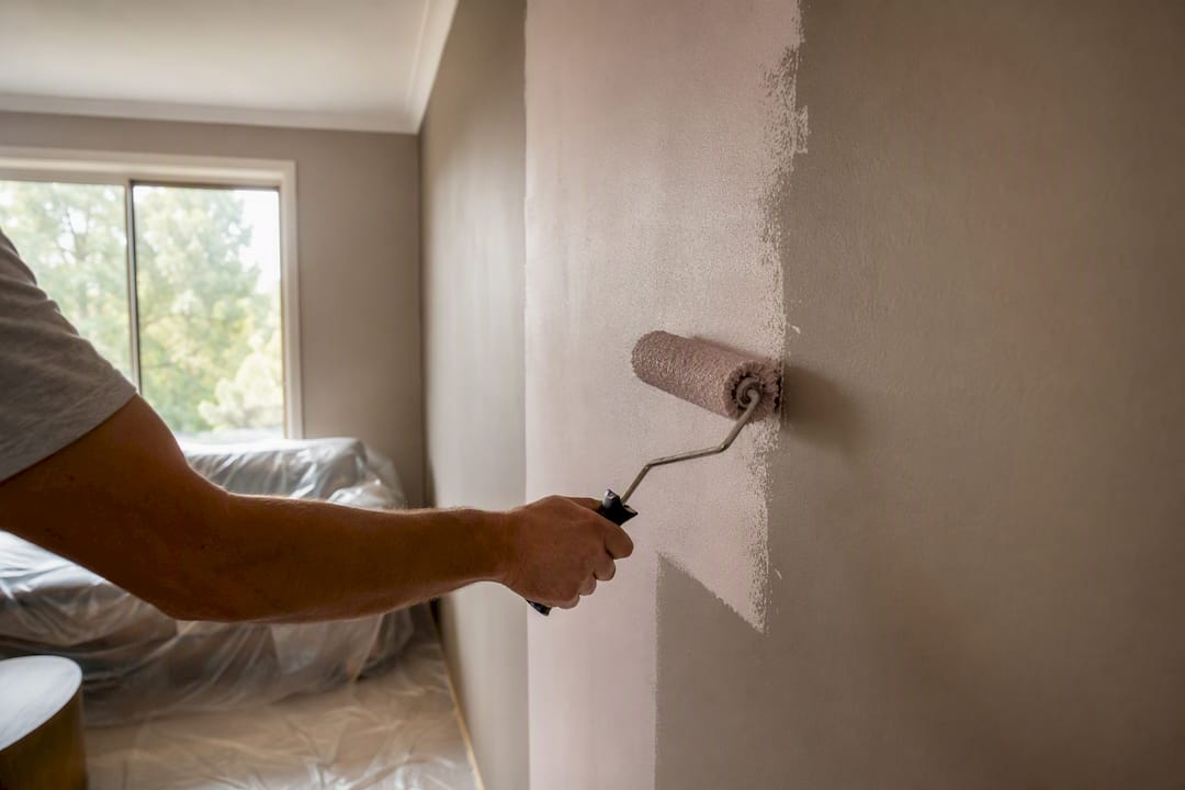Homeowner painting wall with roller