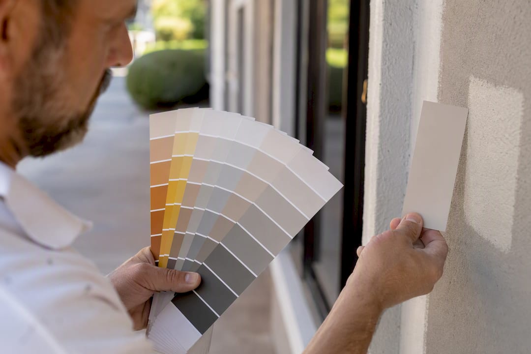 Hands holding paint swatches showing LRV differences