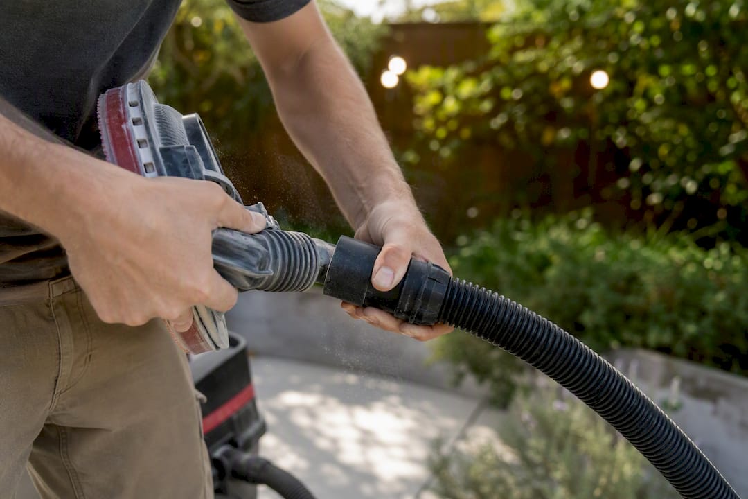 Close-up hands checking sander hose connection