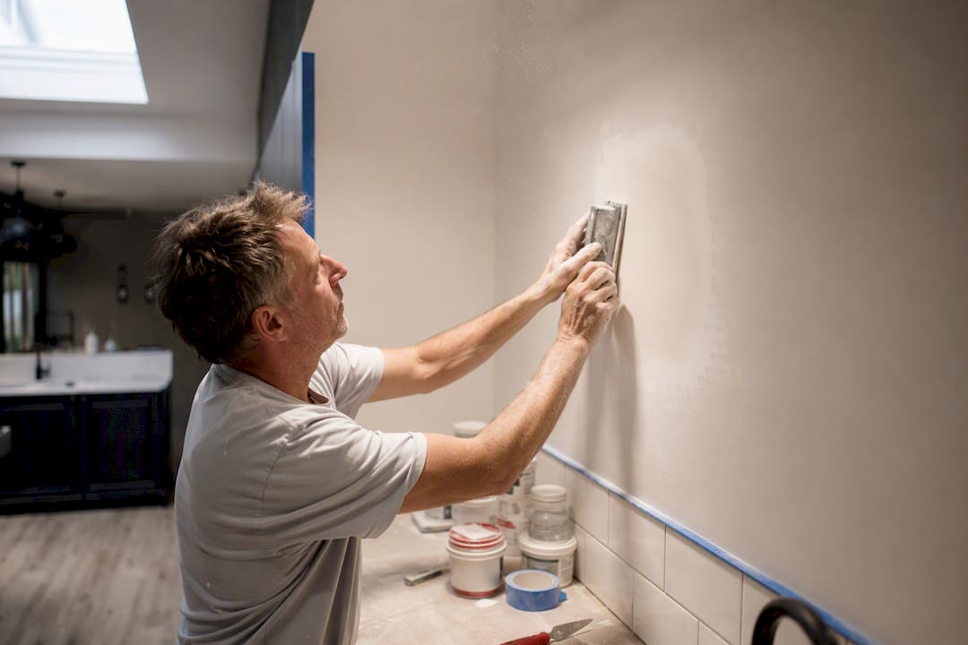 Painter sanding wall patch close-up