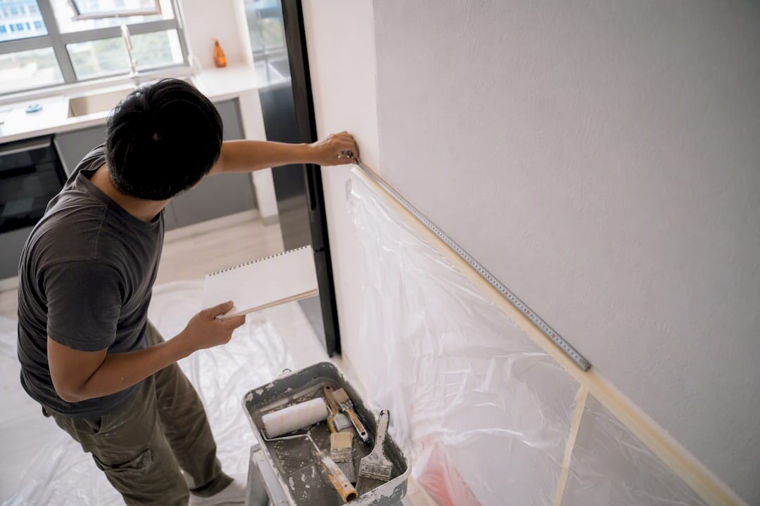 Painter measuring wall for paint coverage